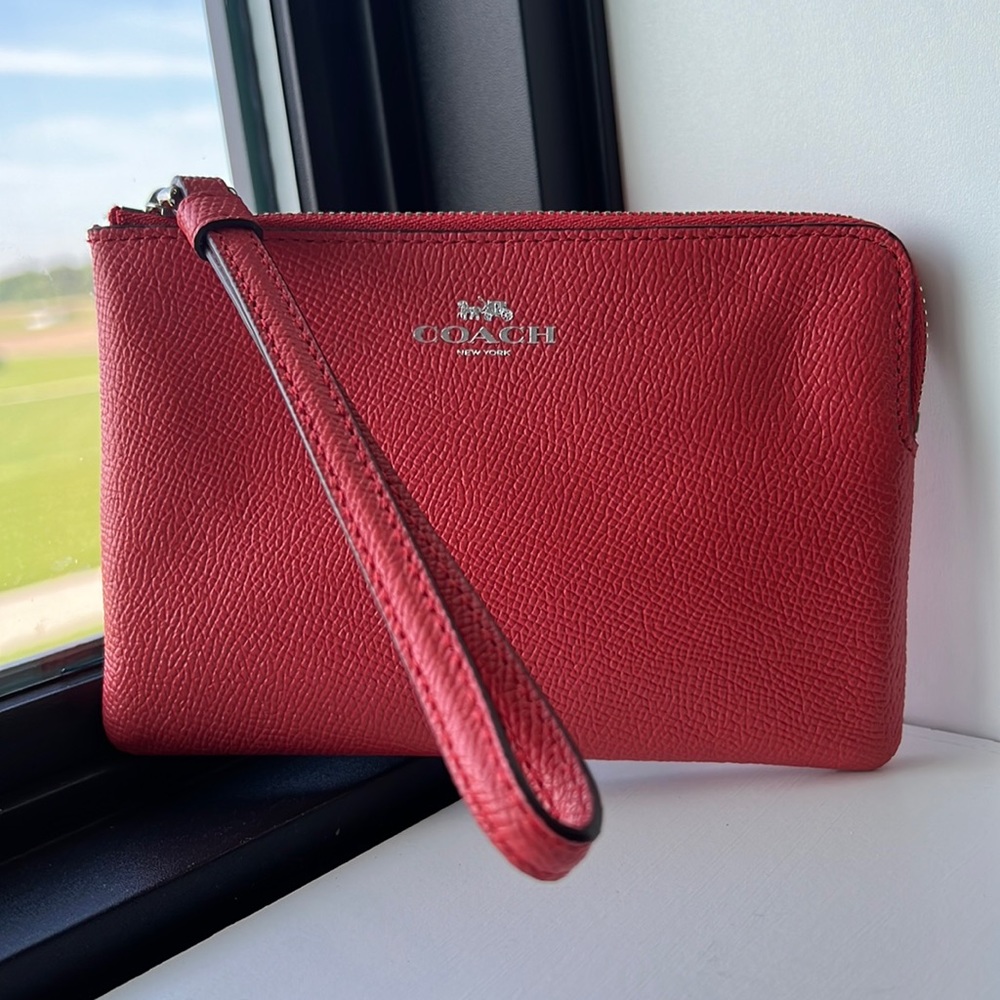 L zip wristlet in Coach’s signature Sun orange color